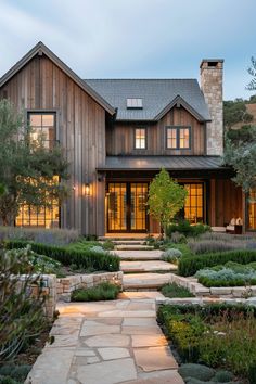 a large house with lots of windows and stone walkway leading to the front door area