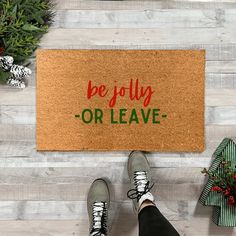 someone standing in front of a door mat that says be jolly or leave