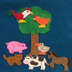 felt farm animals and tree on blue background