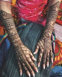 a woman's hands with henna tattoos on her arm and hand, all covered in intricate designs