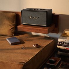 an old marshall radio sitting on top of a bed next to some books and other items