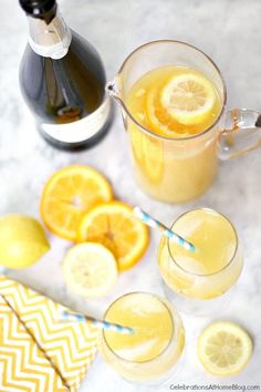 two glasses of lemonade next to some sliced lemons