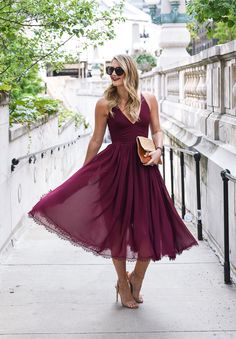 a woman in a purple dress is walking down the street