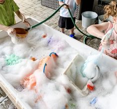 two children are playing with foam and water