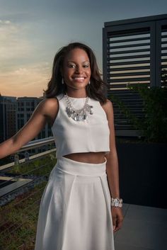 a woman standing on top of a roof with her arms out in front of the camera