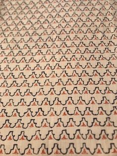 a close up view of a pattern on a table cloth with an orange and black design