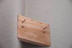 a piece of wood that is attached to a wall with screws and nails on it