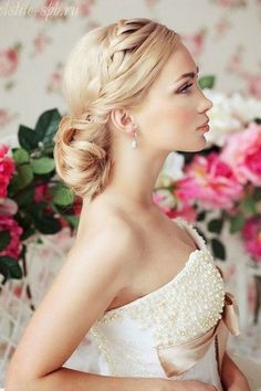 a woman with blonde hair wearing a white dress in front of pink and red flowers