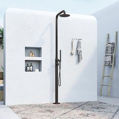 a bathroom with white walls and tiled flooring, including a shower head in the corner