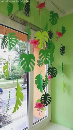 some green and pink paper leaves hanging from a window