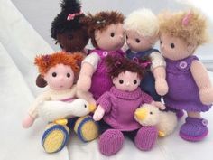 a group of knitted dolls sitting next to each other on a white surface in front of a window