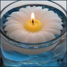 a lit candle in a glass bowl filled with water