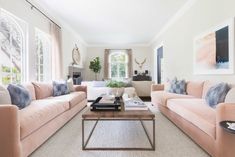 a living room with two couches and a coffee table in front of the window