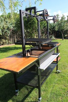 a wooden bench sitting on top of a lush green field next to a metal structure