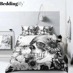 a bed with a skull and sunflowers printed on the cover, next to a lamp