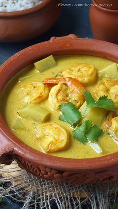 a bowl filled with soup and garnished with cilantro, parsley and lime