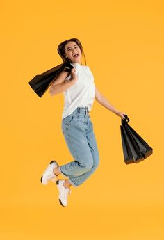 a woman jumping up in the air with shopping bags and a black bag over her head