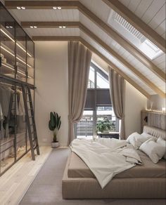 a bed sitting under a window in a bedroom next to a tall wooden shelf filled with books