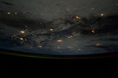 the earth's night sky is seen from space, with lights shining on it