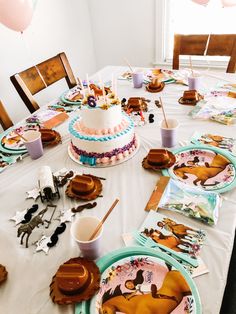 a table topped with plates and cake covered in frosting