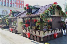 a small house with plants and decorations on the roof is decorated in red, white and green