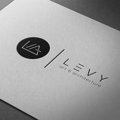 the logo for levy art and architecture is shown on top of a silver business card