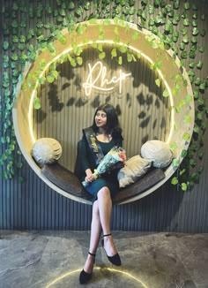 a woman sitting on a couch in front of a sign that says phoer