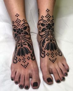 a woman's feet with tattoos on them