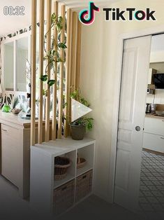 there is a white shelf with plants on it next to the door and mirror in the room