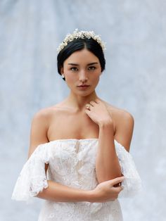 a woman in a white dress with a tiara on her head is posing for the camera