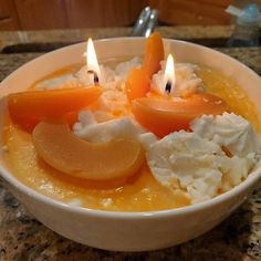 two candles in a bowl filled with food