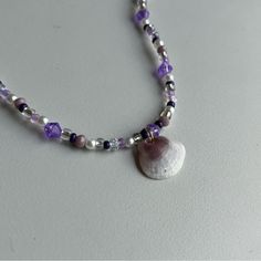 This Necklace Is One Of A Kind And Handmade By Me. It Includes An Assortment Of Purple, Clear, And White Beads With A Shell Pendant In The Middle. The Shell Is A Real Shell That I Collected From The Beach Myself, And The Hole Was Naturally Made By The Ocean. The Shell Has A Protective Clearcoat To Avoid Any Damage And Is Attached By A Gold Jump Ring. This Necklace Has A Gold Lobster, Claw Clasp, And A Gold Chain For Multiple Sizes. If You Like This Piece, Please Check Out My Other Items In My Shop. If You Have Any Questions Please, I Am Happy To Help. Unique Shell-shaped Beaded Necklace Gift, Elegant Beaded Abalone Shell Necklace, Handmade Blue Shell-shaped Necklace, Blue Beaded Shell-shaped Necklace, Unique Beaded Shell-shaped Necklace, Shell Pendant, White Beads, Purple Gold, Jump Rings