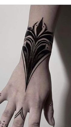 a woman's hand with a black and white tattoo on it