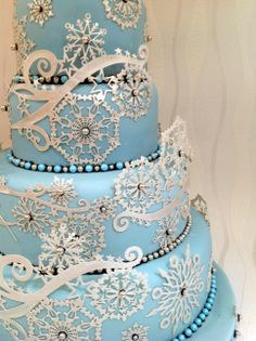 a blue and white wedding cake with snowflakes on it