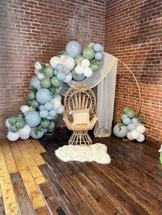 a room with balloons and a chair on the floor in front of a brick wall