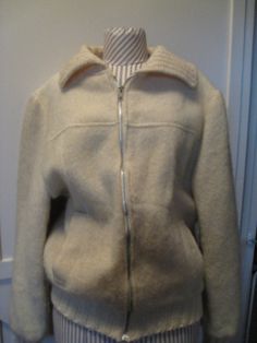 "Hand Made Wool Coat With Sweater Knit Cuffs, Collar And Around The Bottom. Ivory Yellow In Color. Lined With An Acetate Lining. 22\" Ivory Metal Zipper. Possibly From The 1980s with A Blousy Style. Side Front Pockets, Yoke And Top Stitching. Excellent Vintage Condition. No Rips, Tears Or Stains. 1 Very Tiny Place On The Back Of One Sleeve That The Weave Is Loose. Jacket Has A Fluffy Sweater Look And Feel. No Size Listed But Probably Best Fits A Womens Medium-Large. Please Check Measurements For Cream Wool Long Sleeve Outerwear, Fitted Cream Collared Outerwear, Vintage Cream Long-sleeve Outerwear, Vintage Cream Long Sleeve Outerwear, Cream Long Sleeve Vintage Outerwear, Coverall Jumpsuit, Loose Jacket, Zip Coat, Fluffy Sweater