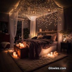 a bedroom with candles lit up on the floor and lights hanging from the ceiling over the bed