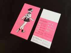 a pink and white ticket sitting on top of a black table next to a piece of paper