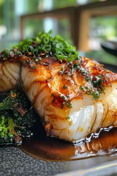 some kind of fish on a plate with broccoli