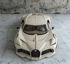 a white sports car parked in front of a concrete wall