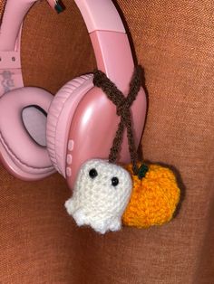 a pair of headphones hanging from the side of a pink wall with a pumpkin on it