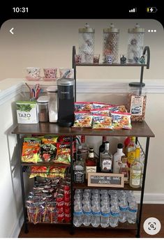 a shelf filled with drinks and snacks on top of a hard wood floor next to a wall