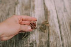 a person holding onto some rings on top of a wooden table