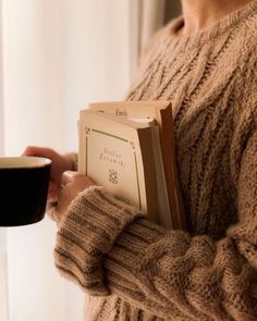 a woman holding a coffee cup and book