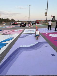 a person sitting on the ground in front of some chalk drawings