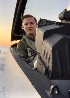 a man is sitting in the cockpit of an airplane and looking at the cameraman