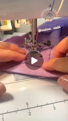 someone is using a sewing machine to sew on the pink material with their hands