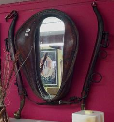 a mirror on the wall above a sink in a room with pink walls and furniture