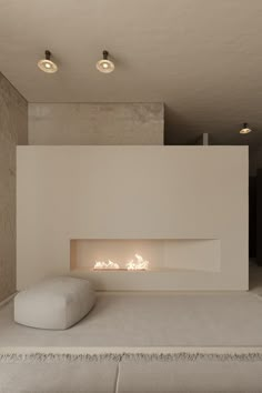 a modern fireplace in the middle of a living room with white walls and flooring