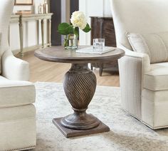 a living room with two chairs and a table in the middle on top of a rug